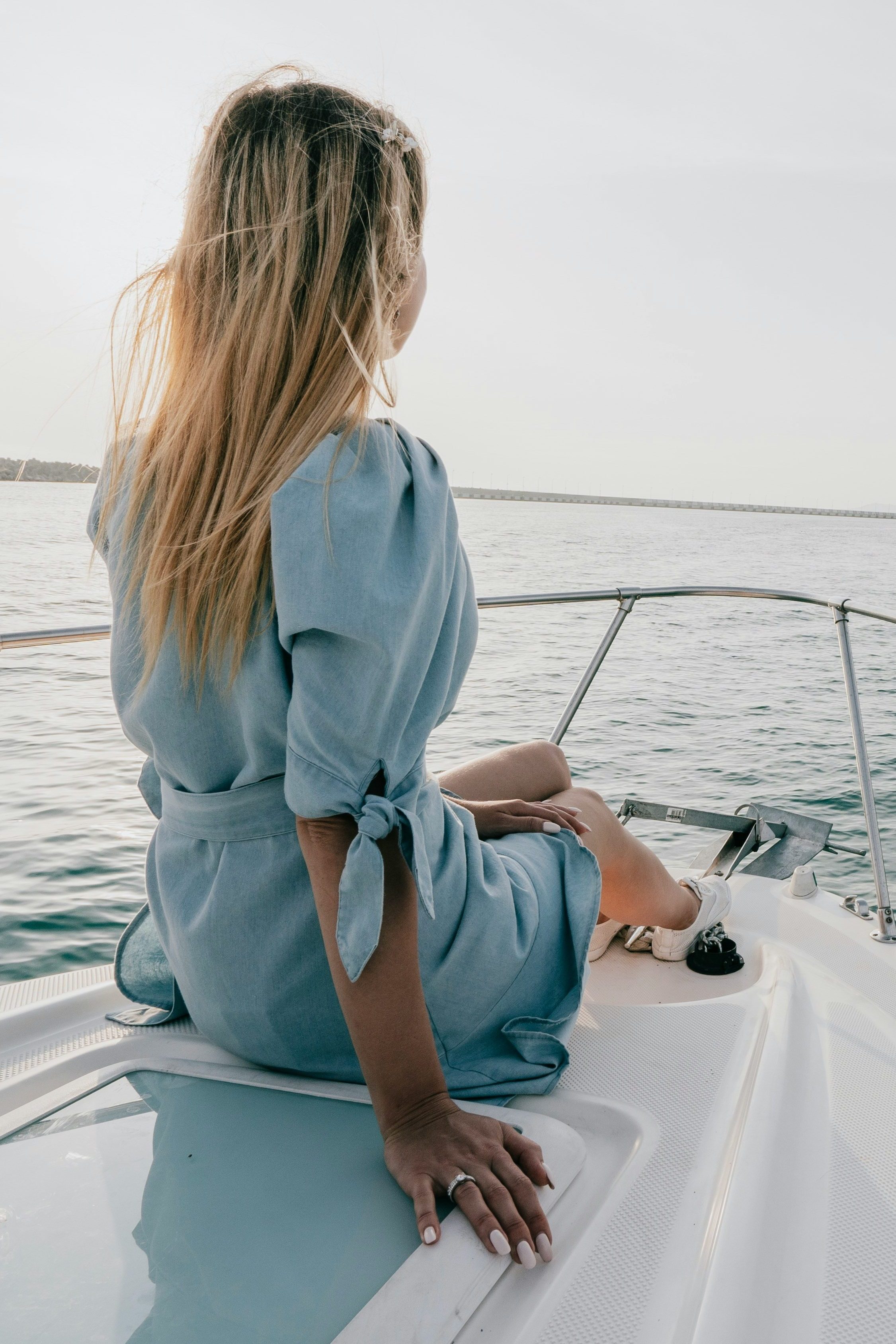 Femme blonde en robe bleue sur le pont d'un bateau
©Dmitri Tomashek 